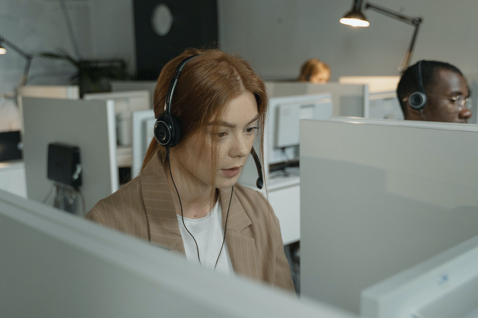 woman in brown blazer wearing black headphones